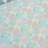 Floral patterned fabric with pink flowers and blue bows on a light blue background.