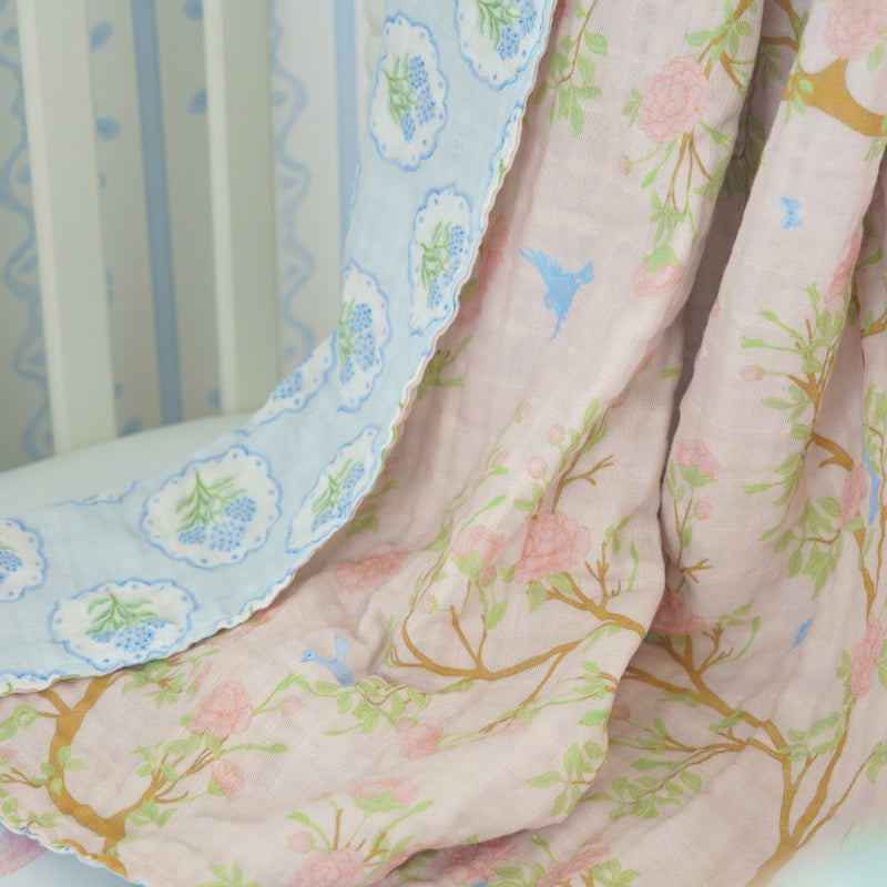 Floral crib sheet draped over a crib with a white background
