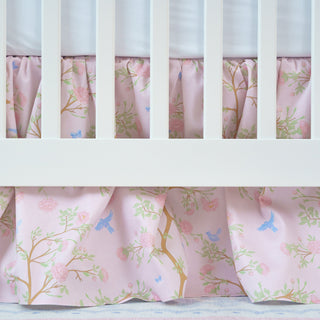 Crib with pink floral crib skirt and white crib bars