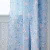 Floral patterned curtains on a wooden floor with a light blue color scheme.