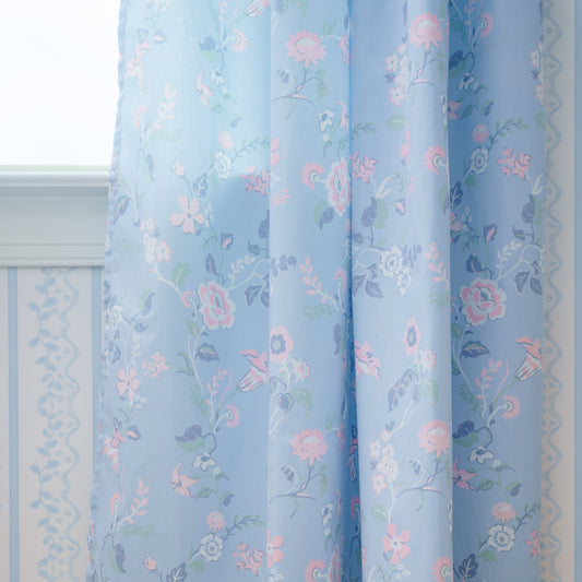 Floral patterned curtains on a wooden floor with a light blue color scheme.