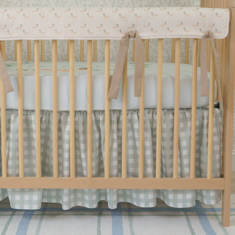 A crib bedding set with a duckling design, including a personalized blanket with the name 'William', displayed in a nursery room.